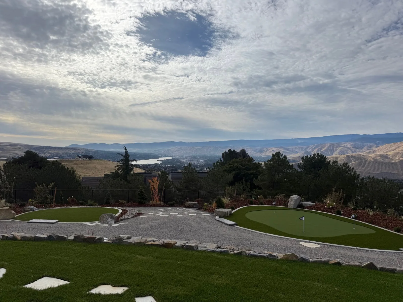 Putting green and curved walkway overlooking the river valley and distant mountains