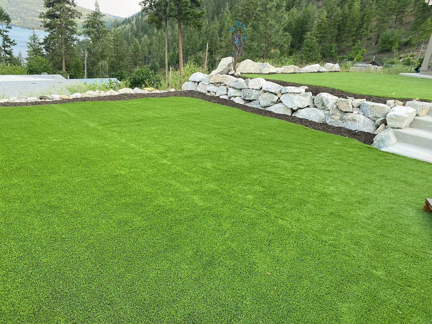 Artificial turf lawn beside a rock wall