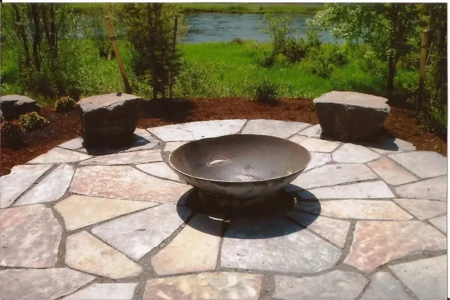 Metal fire bowl on a flagstone patio overlooking the river