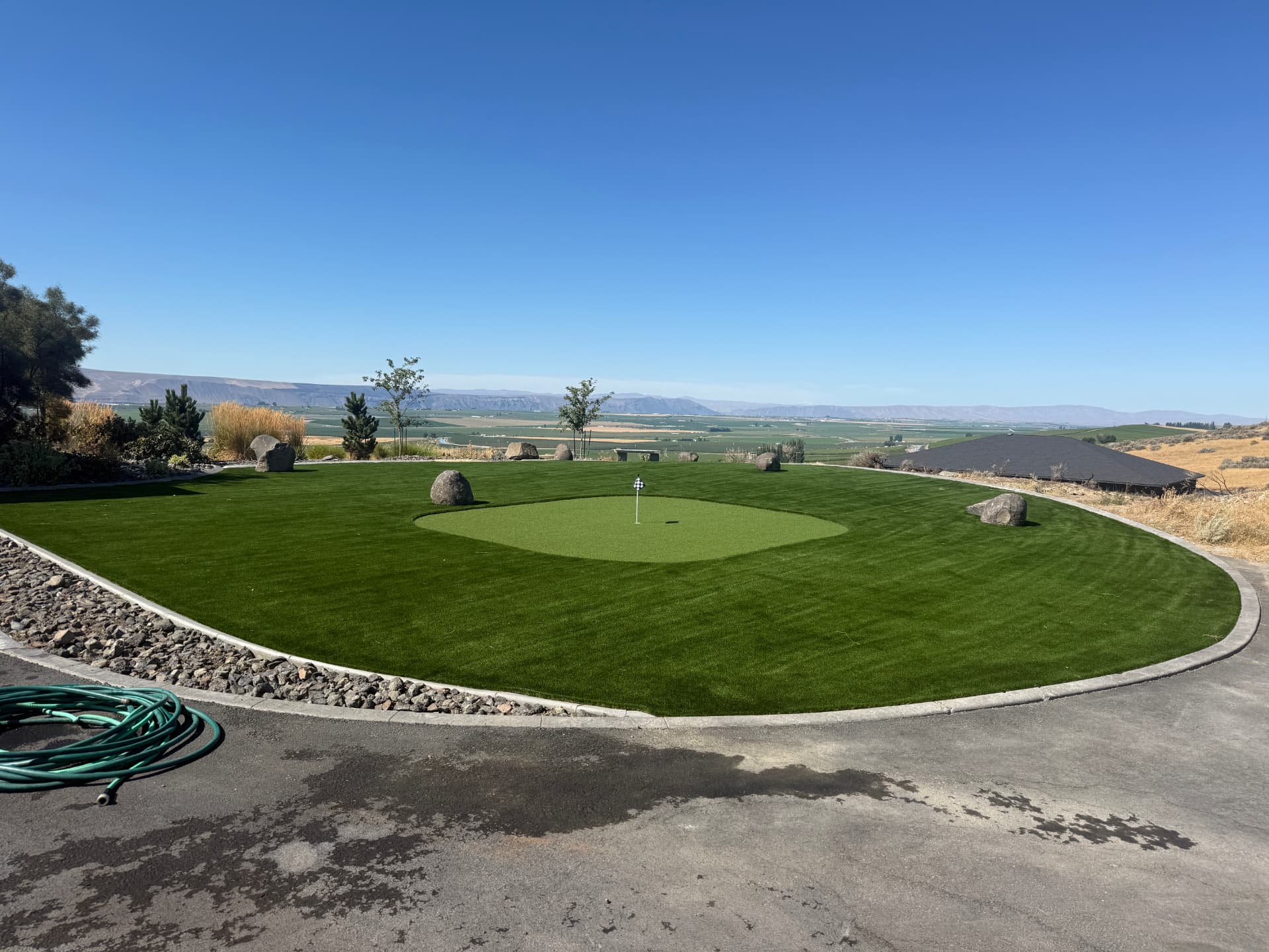 Finished putting green framed by boulders and valley views